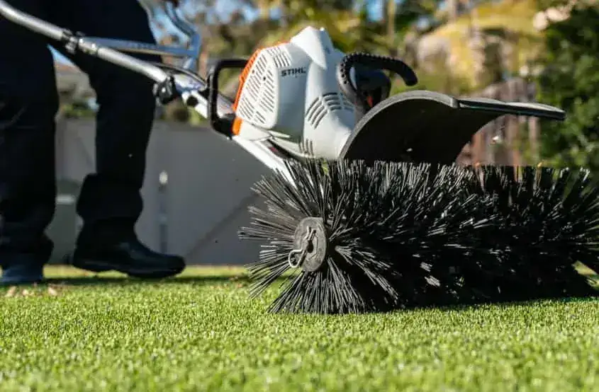 TurFresh technician removing debris from artificial turf