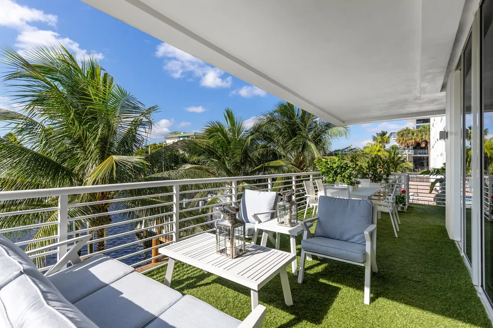 Waterfront courtyard terrace with clean artificial turf and outdoor seating