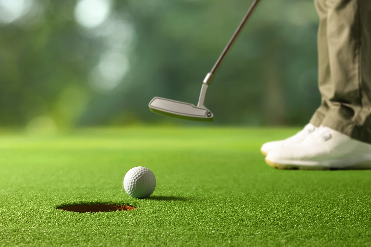 Golfer putting toward the cup on a smooth, true-rolling putting green