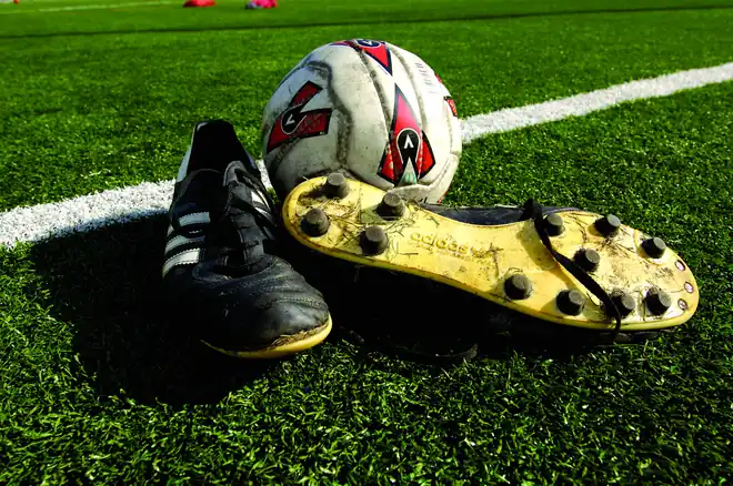 Soccer cleats and ball on high-traffic artificial turf kept clean with TurFresh TurfAid maintenance