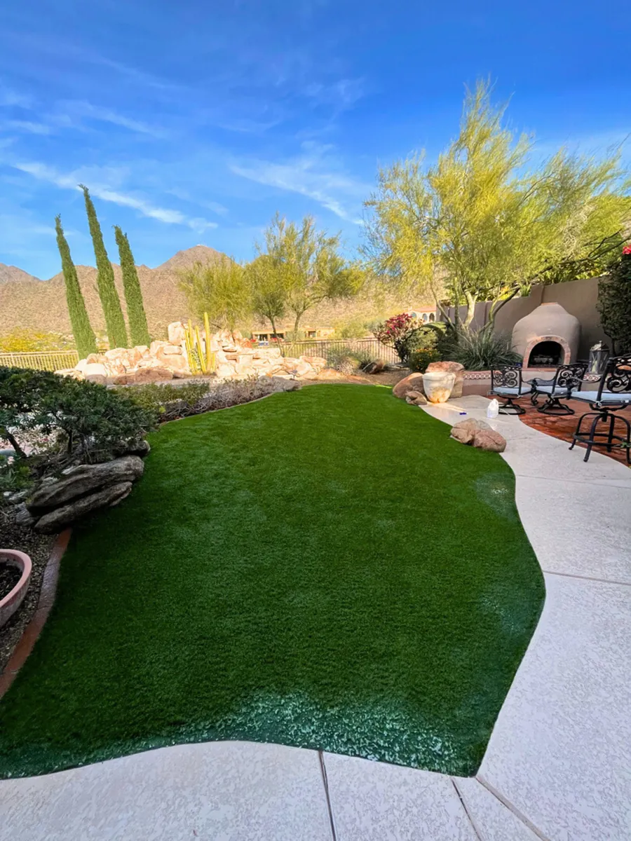 Completed TurFresh turf care visit on a North Scottsdale desert backyard lawn framed by boulders and desert planting
