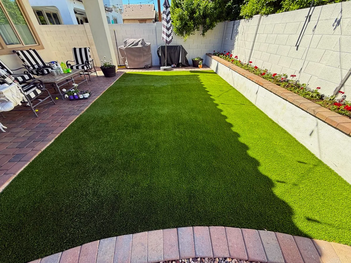 Completed TurFresh turf cleaning on a walled Arizona backyard lawn with a raised flower bed