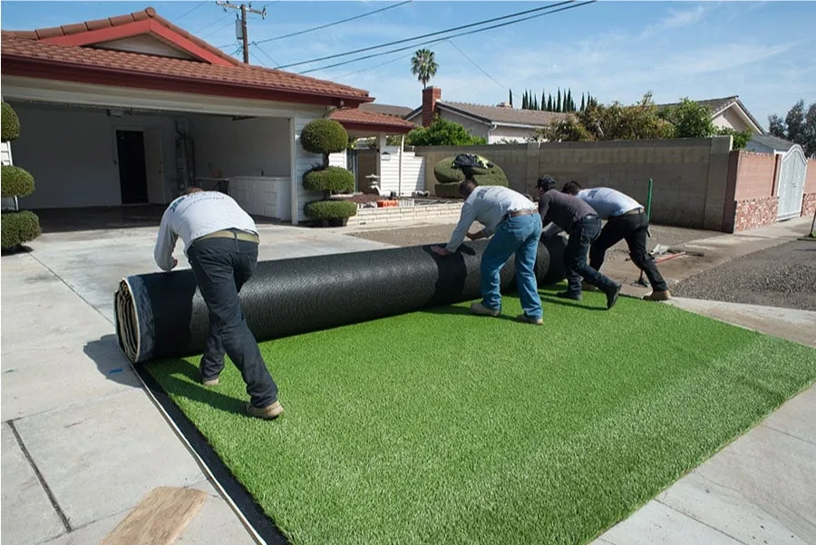 TurFresh TurfSwap crew unrolling a new artificial turf roll during a residential replacement