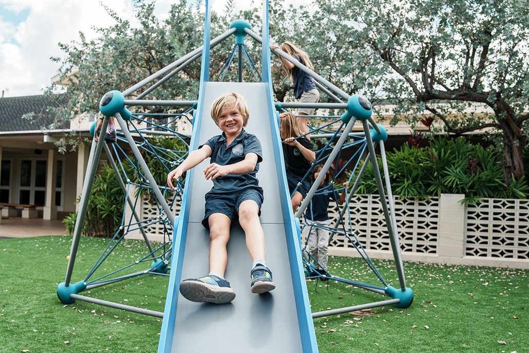 Child playing safely on clean maintained artificial turf at a school or daycare facility.