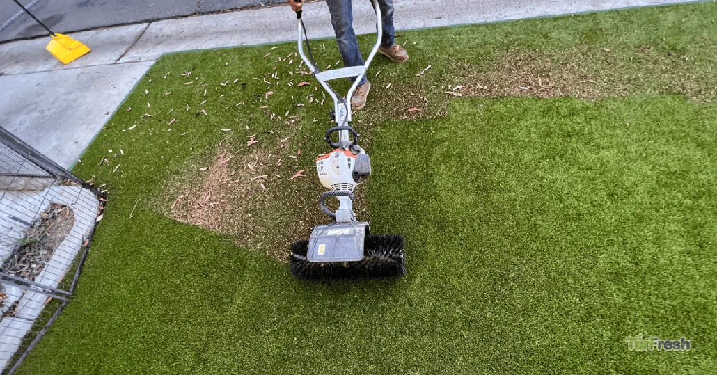 Overhead view of TurFresh technician power brooming dirty artificial turf to lift debris and rebloom fibers for a fresh green lawn