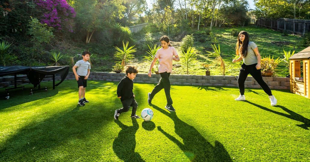 Family enjoying clean artificial turf during Thanksgiving gathering after TurFresh pre-holiday cleaning.